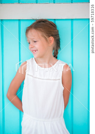 Adorable little girl outdoors against colorful house in Caribbean. Traditional caribbean colorful 59718316
