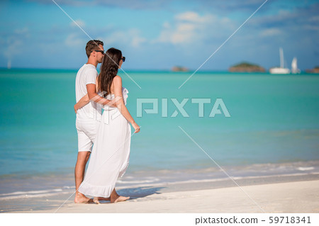 Family of two walking on the beach 59718341