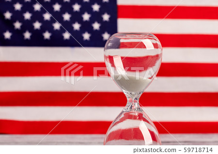 Hourglass on national USA flag background. Hourglass on national USA flag background. 59718714