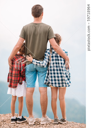 Beautiful kids and happy man in mountains in the background of fog 59718964