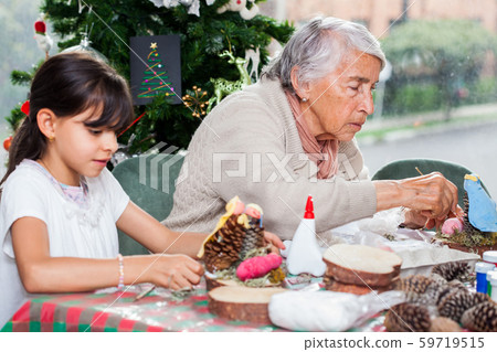 Grandmother teaching her granddaughter how to make christmas Nativity crafts Grandmother teaching her granddaughter how to make christmas Nativity crafts 59719515