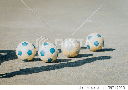 4 soccer balls on the soil ground 59719923
