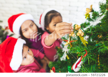 Cute asian child girls and their mother are decorating christmas tree 59721226