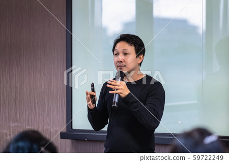 Asian Speaker or lecture with casual suit on the stage in front of the room presenting with the screen in the conference hall or seminar meeting room, business and education concept 59722249