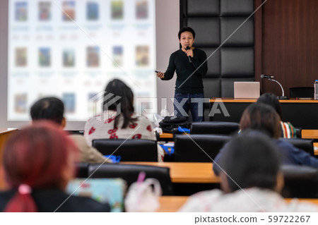 Asian Speaker or lecture with casual suit on the stage presenting via projector screen in the conference hall or seminar meeting room to Audience, business education and Seminar concept 59722267