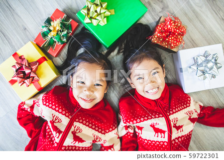 Two cute asian child girls laying down on the floor and play together Two cute asian child girls laying down on the floor and play together 59722301