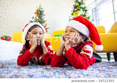 Two cute asian child girls laying down on the floor and play together Two cute asian child girls laying down on the floor and play together 59722303