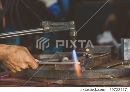 Closeup machinist hand bending the steel by torch in metalworking factory, lathe grinding metalworking industry concept 59722517