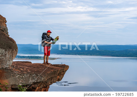 man traveler with backpack looking at the map on man traveler with backpack looking at the map on 59722685