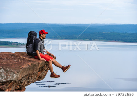 man traveler with backpack sitting on edge of man traveler with backpack sitting on edge of 59722686