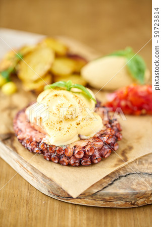 Closeup Roasted octopus BBQ with Baked potato. Wooden plate. Restaurant menu Closeup Roasted octopus BBQ with Baked potato. Wooden plate. Restaurant menu 59723814