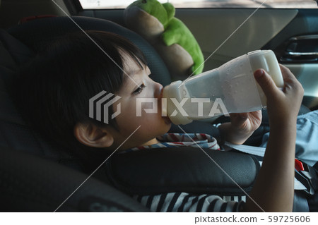 baby boy sucking milk on car seat safety drive 59725606