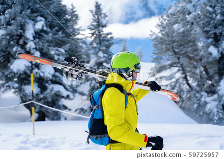 Portrait of sportive man in helmet with skis on his shoulder Portrait of sportive man in helmet with skis on his shoulder 59725957