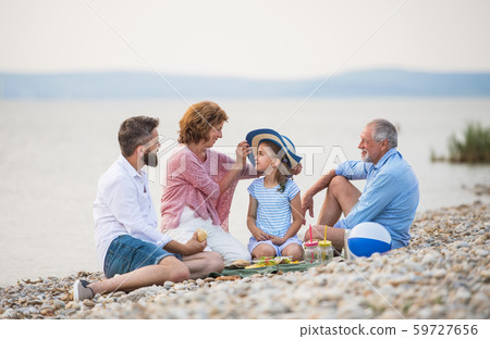 Multigeneration family on a holiday by the lake, having picnic. 59727656