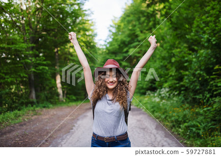 Young tourist woman traveller walking in nature, stretching arms. Young tourist woman traveller walking in nature, stretching arms. 59727881
