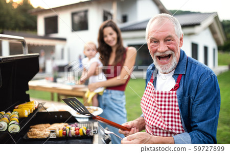 Portrait of multigeneration family outdoors on garden barbecue, grilling. 59727899
