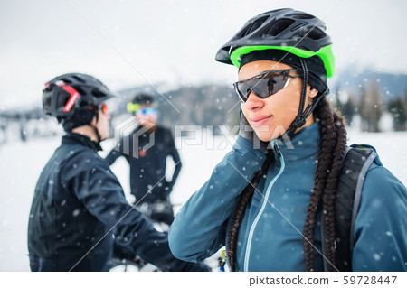 Female mountain biker with friends standing outdoors in winter. 59728447