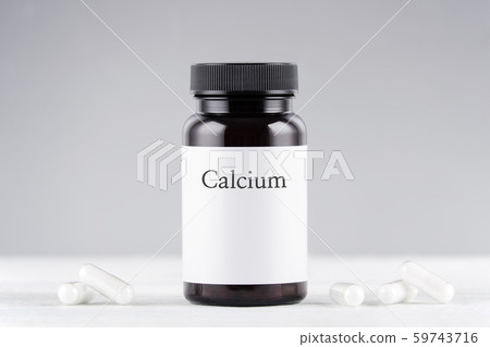 nutritional supplement calcium bottle and capsules on gray 59743716