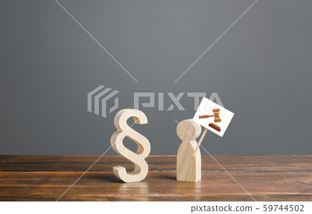 Paragraph symbol and man with a drawing of a judge hammer gavel on a sign. Call to trial against a criminal or a corrupt official. Justice and judicial system. Legal assistance, lawyers services Paragraph symbol and man with a drawing of a judge hammer gavel on a sign. Call to trial against a criminal or a corrupt official. Justice and judicial system. Legal assistance, lawyers services 59744502