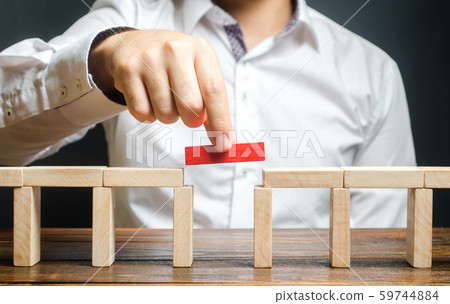 A man is completing the constructionA man is completing the construction of a bridge. Build bridges, make connections and useful contacts. Improving and developing a business. New innovat of a bridge. A man is completing the constructionA man is completing the construction of a bridge. Build bridges, make connections and useful contacts. Improving and developing a business. New innovat of a bridge. 59744884