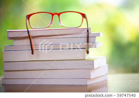 Orange eyeglasses with books on wooden table, Bokeh garden background, Close up & Macro shot, Selective focus, Stationery concept Orange eyeglasses with books on wooden table, Bokeh garden background, Close up & Macro shot, Selective focus, Stationery concept 59747540
