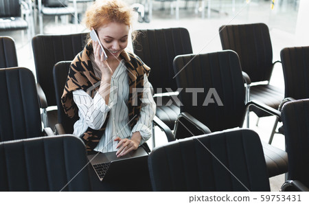 Young businesswoman sitting alone in conference room with laptop Young businesswoman sitting alone in conference room with laptop 59753431
