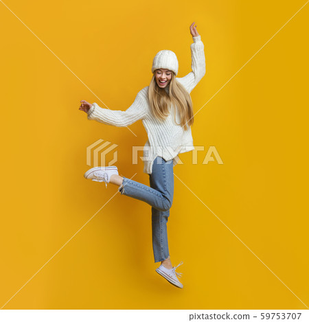 Cheerful blonde girl dancing and jumping in the air 59753707