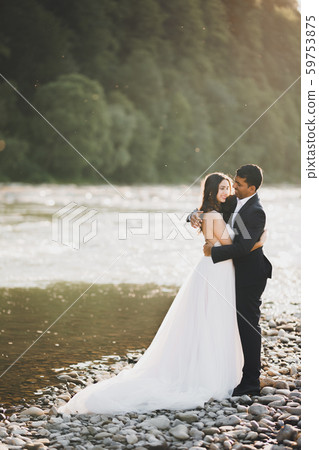 Wedding couple on the nature is hugging each other. Beautiful model girl in white dress. Man in suit Wedding couple on the nature is hugging each other. Beautiful model girl in white dress. Man in suit 59753875