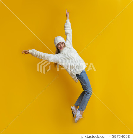 Carefree winter girl standing on her toes, leaning backward Carefree winter girl standing on her toes, leaning backward 59754068