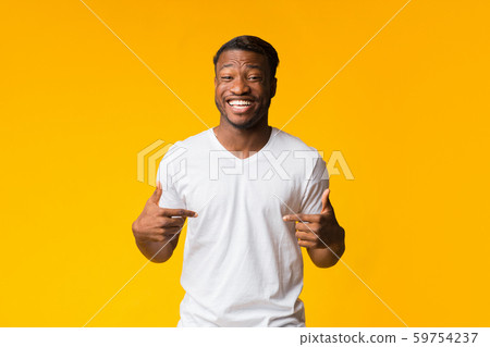 Black Man Pointing Fingers At Himself Smiling Over Yellow Background 59754237