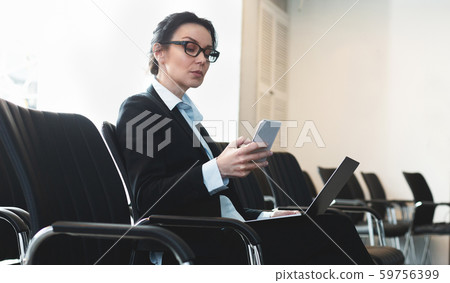 Businesswoman preparing for presentation, sitting in empty conference room Businesswoman preparing for presentation, sitting in empty conference room 59756399