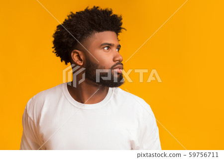 Skeptical young black man looking aside at free space Skeptical young black man looking aside at free space 59756711