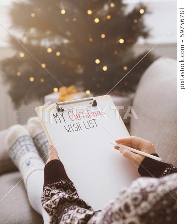 Woman creating Christmas wish list at home in funny clothes Woman creating Christmas wish list at home in funny clothes 59756781