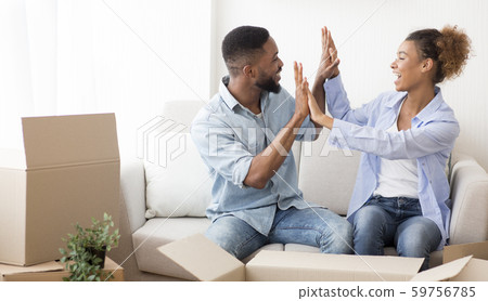 Happy Afro Spouses Giving High-Five Sitting Among Moving Boxes Indoor 59756785