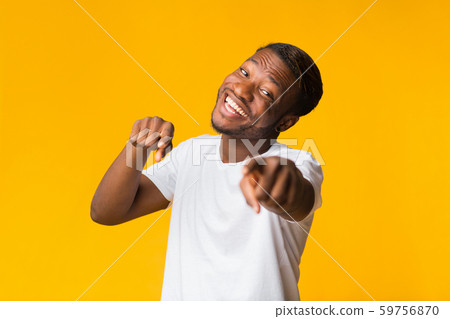Smiling Black Guy Pointing Fingers At Camera Standing, Yellow Background Smiling Black Guy Pointing Fingers At Camera Standing, Yellow Background 59756870