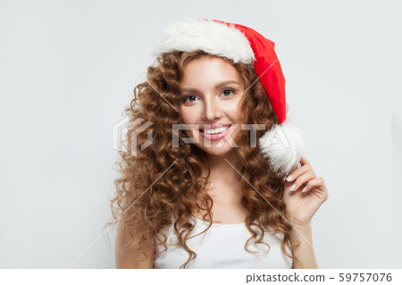 Happy young woman in Santa hat smiling on white Happy young woman in Santa hat smiling on white 59757076