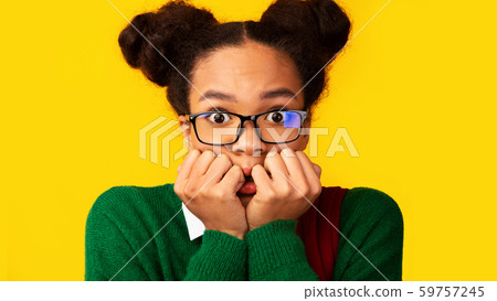 Portrait of afraid black teen looking shocked Portrait of afraid black teen looking shocked 59757245