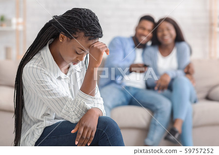 Jealous Girl Sitting Alone While Her Dating Friends Cuddling On Sofa 59757252