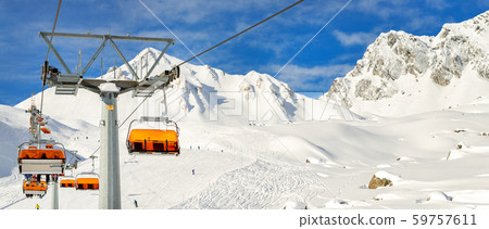 Ski lift ropeway on hilghland alpine mountain winter resort on bright sunny day. Ski chairlift cable 59757611
