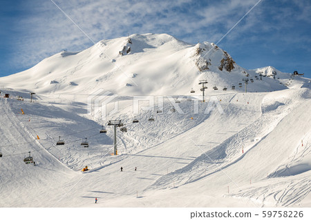 Ski lift ropeway on hilghland alpine mountain winter resort on bright sunny day. Ski chairlift cable 59758226