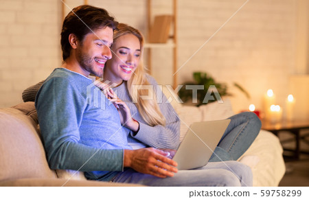 Couple Watching Film On Laptop Sitting On Couch At Home Couple Watching Film On Laptop Sitting On Couch At Home 59758299
