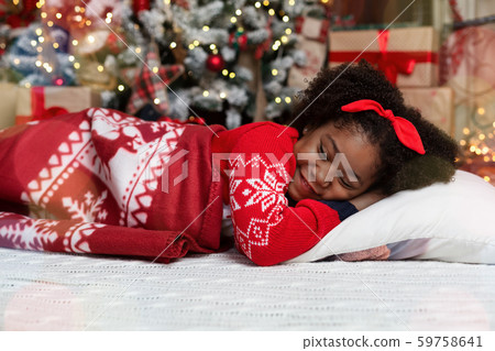 Adorable little black girl sleeping near christmas tree 59758641