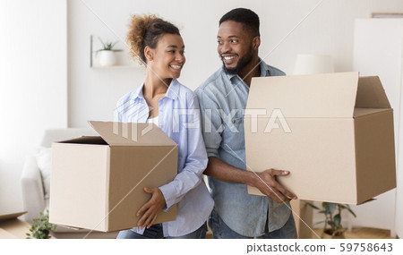 African American Spouses Carrying Moving Boxes Smiling Standing Back-To-Back Indoor African American Spouses Carrying Moving Boxes Smiling Standing Back-To-Back Indoor 59758643