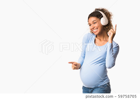 Happy pregnant woman listening music and dancing Happy pregnant woman listening music and dancing 59758705
