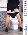 back of woman that stays near toilet bowl 59759838