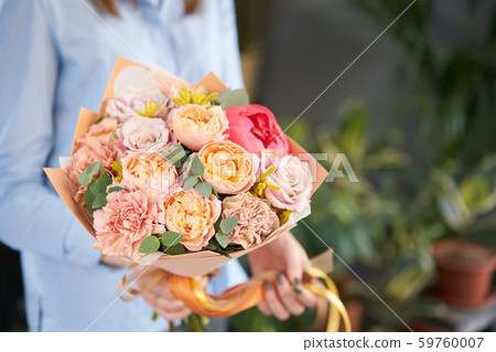 European floral shop. Beautiful bouquet of mixed flowers in womans hands. the work of the florist at European floral shop. Beautiful bouquet of mixed flowers in womans hands. the work of the florist at 59760007