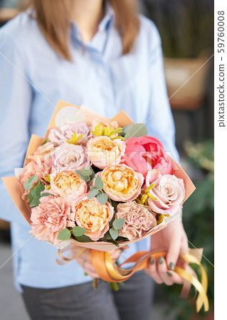 European floral shop. Beautiful bouquet of mixed flowers in womans hands. the work of the florist at European floral shop. Beautiful bouquet of mixed flowers in womans hands. the work of the florist at 59760008