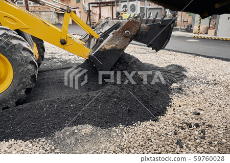 A tractor unloads the asphalt. Large heavy machinery is carrying out road repair work. Laying new A tractor unloads the asphalt. Large heavy machinery is carrying out road repair work. Laying new 59760028