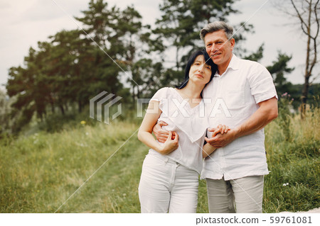 Beautiful adult couple spend time in a summer field Beautiful adult couple spend time in a summer field 59761081