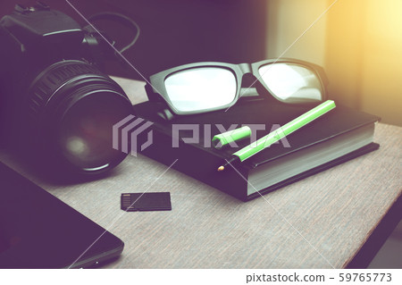 light green pen on black notebook organizer and digital camera with memory card on wooden table light green pen on black notebook organizer and digital camera with memory card on wooden table 59765773